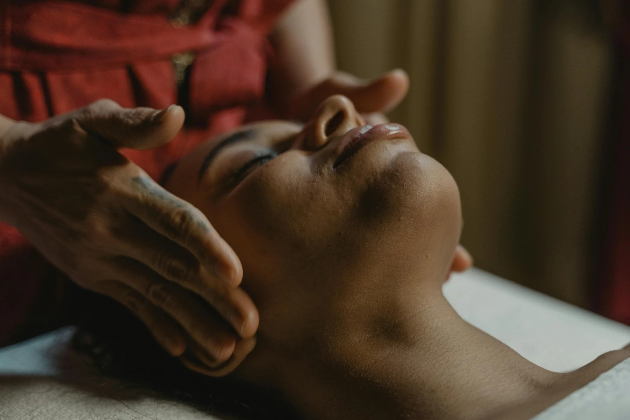 mains qui massent un visage de femme