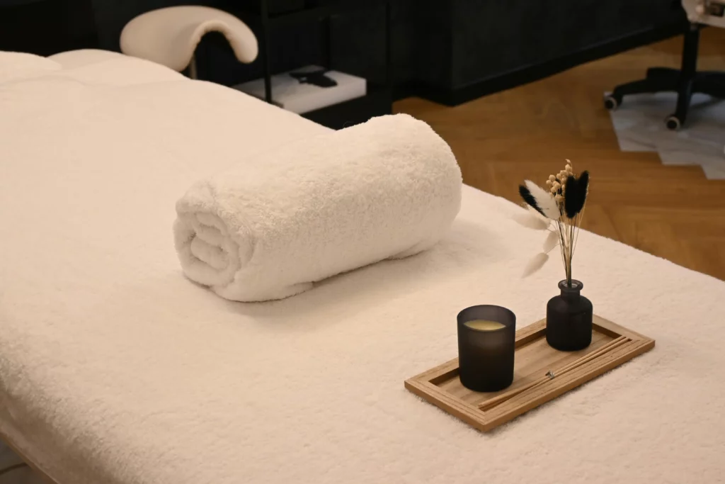 table de massages avec une serviette et une bougie