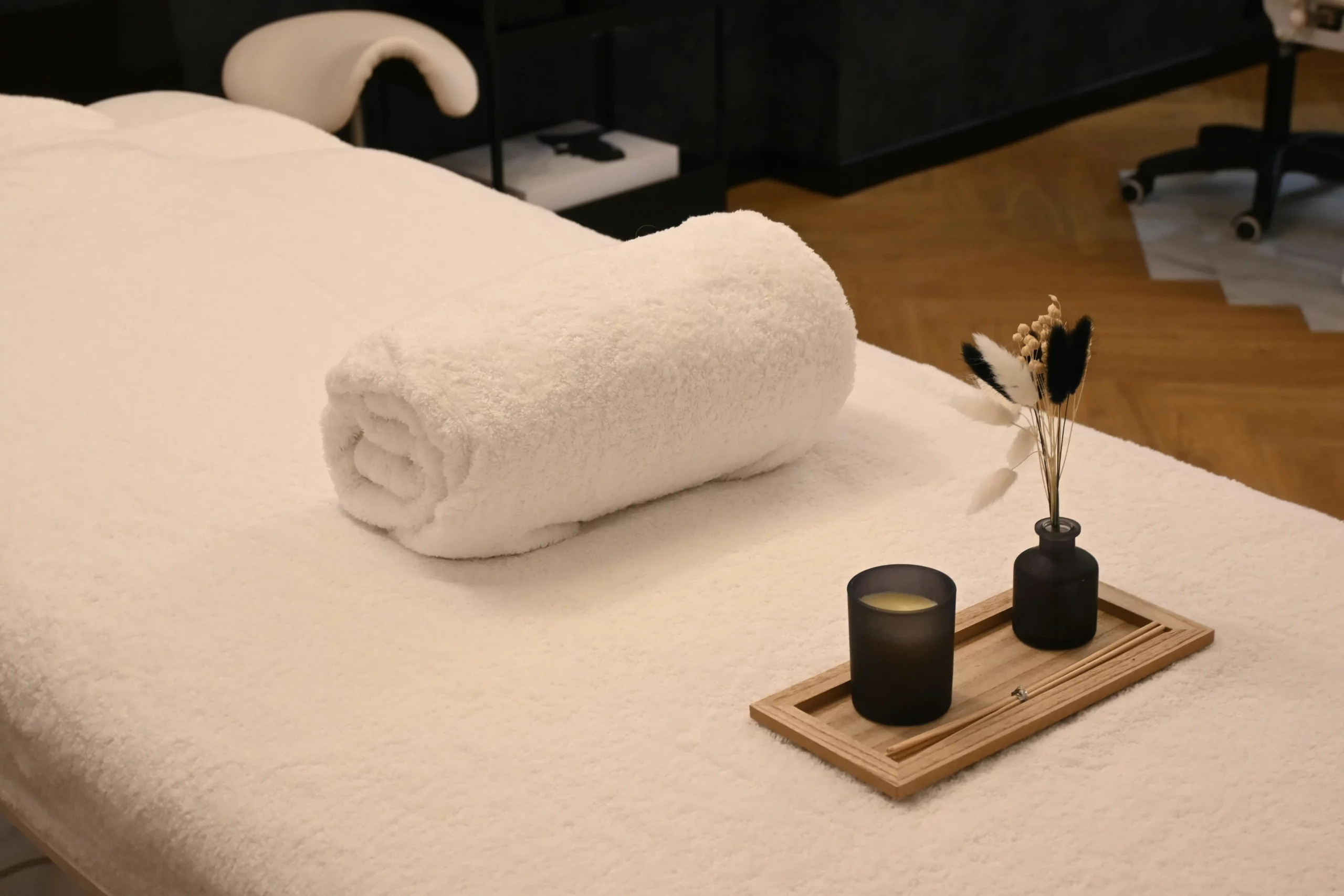 table de massages avec une serviette et une bougie
